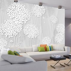 a living room with white furniture and flowers on the wall