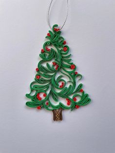 a green christmas tree ornament with red berries