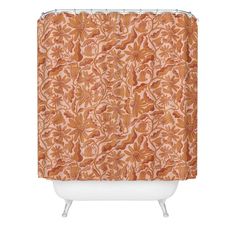 a shower curtain with an orange and white flower pattern on the outside, in front of a