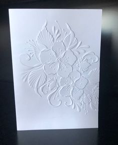 a white card with an intricate design on it