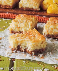 several pieces of coconut cake sitting on top of a paper towel next to other desserts