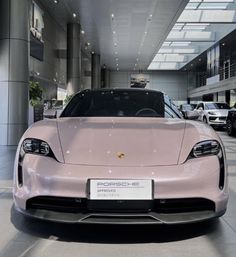 a pink sports car is parked in a showroom