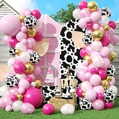 a pink and gold birthday party with balloons, cake and decorations in front of a house