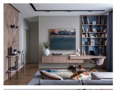 a living room filled with furniture and a large painting on the wall above it's desk