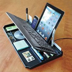 an open laptop computer sitting on top of a desk next to a tablet and pen