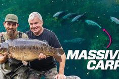 two men pose for a photo while holding a large fish