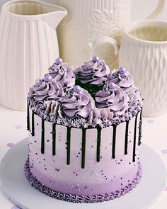 a cake with purple frosting and sprinkles sitting on a white plate