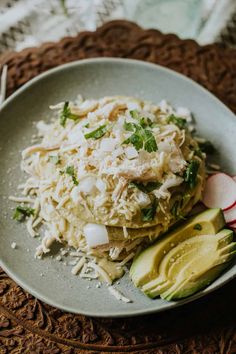 a white plate topped with food next to sliced avocado