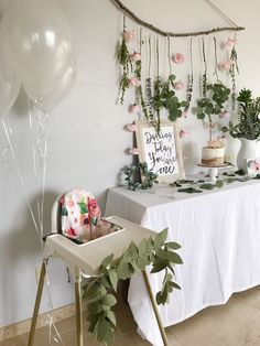 a baby's first birthday party with balloons and greenery