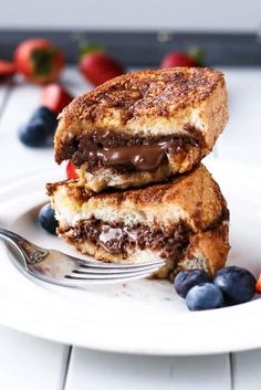 two waffles stacked on top of each other with blueberries and strawberries