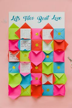 colorful origami envelopes are arranged on a pink background with the words let's taco bout love