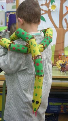 a young boy wearing a green and yellow scarf