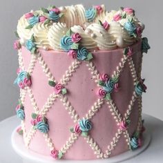 a pink cake with white frosting and colorful decorations