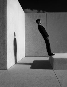 an image of a man standing in the middle of a room with his shadow on the wall