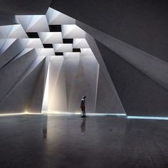 a person standing in an empty room with white walls and geometric shapes on the ceiling