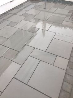 an umbrella is sitting on the ground in front of a building with water puddles