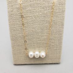 Three freshwater pearls are hand wired into gold filled chain. Sophisticated and dainty, this necklace is perfect for those that prefer a simpler look. Pair with a matching earrings and your outfit is complete. Great for graduates and bridesmaids! All pieces will be packaged together in a cotton filled jewelry box unless otherwise specified. Please let us know if your order is a gift and we will gladly include a handwritten note and complimentary gift wrap. Gold Filled Chain, White Pearl, Matching Earrings, Gift Wrap, Pearl White, Fresh Water, Necklaces Bracelets, Freshwater Pearls, Gold Filled