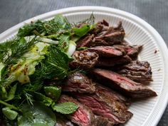 a white plate topped with steak and greens