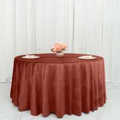 a round table with two vases on it and an orange cloth draped over the top