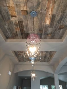 a chandelier hanging from the ceiling in a room with wood paneled ceilings