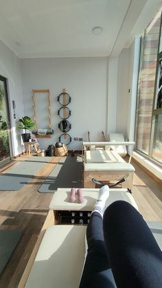 a person is sitting on a yoga mat in the middle of a room with lots of windows