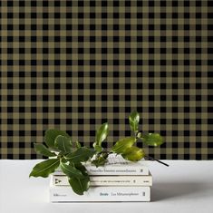 three books stacked on top of each other in front of a black and white checkered wall