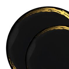 two black and gold plates sitting next to each other