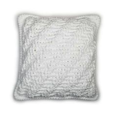 a white pillow that is made out of knitted fabric and has a square shape