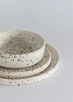 three white and black speckled bowls stacked on top of each other