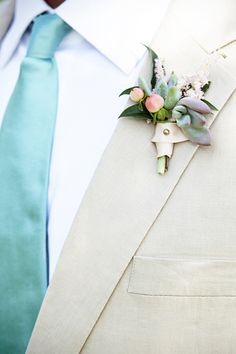 a man wearing a suit and tie with a boutonniere on his lapel