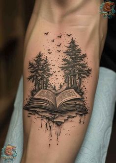 an open book with trees and birds flying out of it on the side of a man's leg