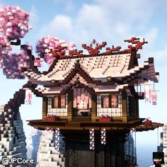 a house made out of legos with pink flowers on the roof and trees in front