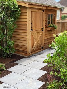 a small wooden shed sitting in the middle of a garden