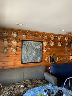 a living room filled with furniture and deer heads on the wall