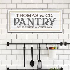 there is a sign that says thomas & co pantry on the wall above utensils