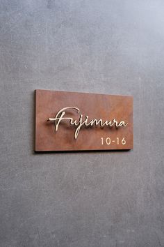 a wooden sign that says primara on the side of a gray wall with gold lettering