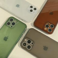 four different colored iphones sitting next to each other on top of a white table