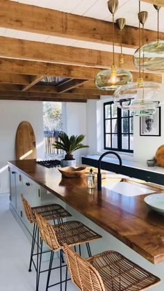 a kitchen with wooden counter tops and stools next to an island in the middle