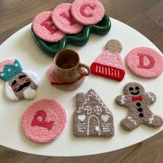 knitted coasters are arranged on a table with coffee cup and cookie cutters