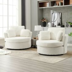 a living room with two white chairs and a rug