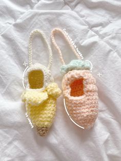 two crocheted baby shoes sitting on top of a white sheet