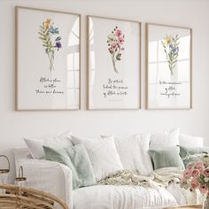 three framed floral prints on the wall above a white couch in a living room with wicker coffee table