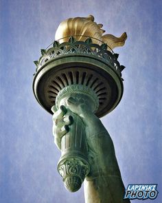 the statue of liberty has its hands on it's head and is holding a torch