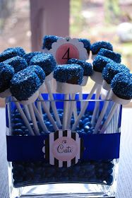 blue cake pops are arranged in a clear container