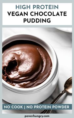 a white bowl filled with chocolate pudding on top of a table next to a spoon