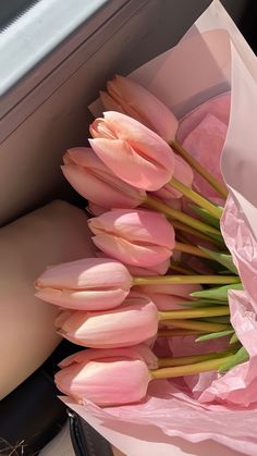 a bouquet of pink tulips in a paper bag