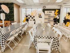 a room filled with tables and chairs covered in black and white checkered cloths