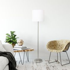 a living room with a white couch, chair and lamp on the floor next to a coffee table