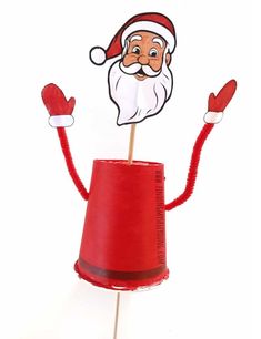 a santa clause on top of a red cupcake with his hands in the air