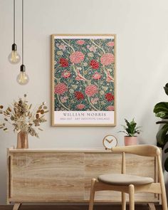 a wooden bench sitting in front of a wall with a framed flower print on it